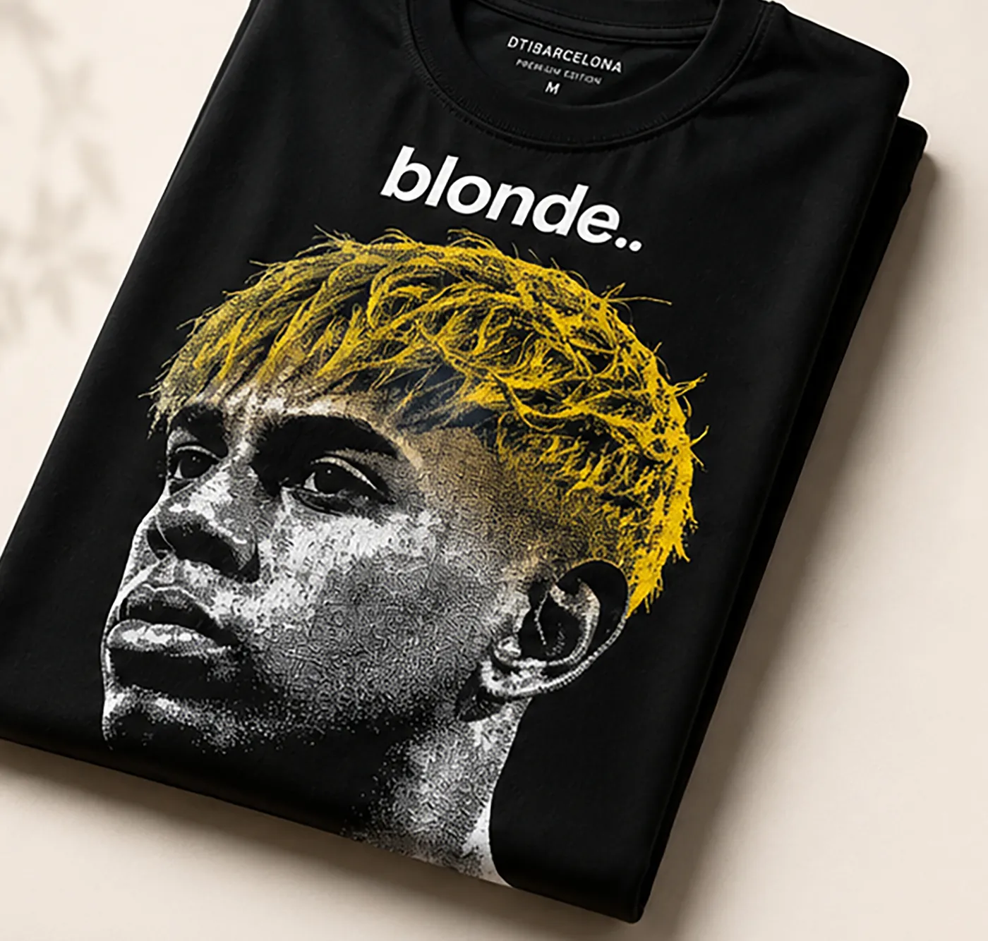 Camiseta negra Blonde Portrait Tee doblada con retrato impreso en DTI